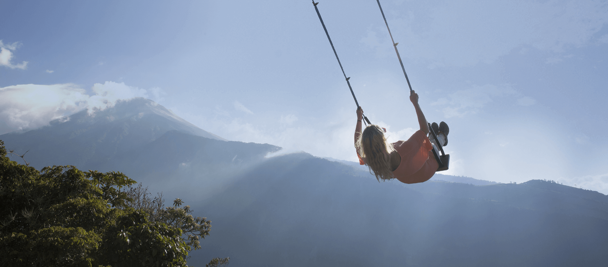 Girl on swing against a mountain backdrop